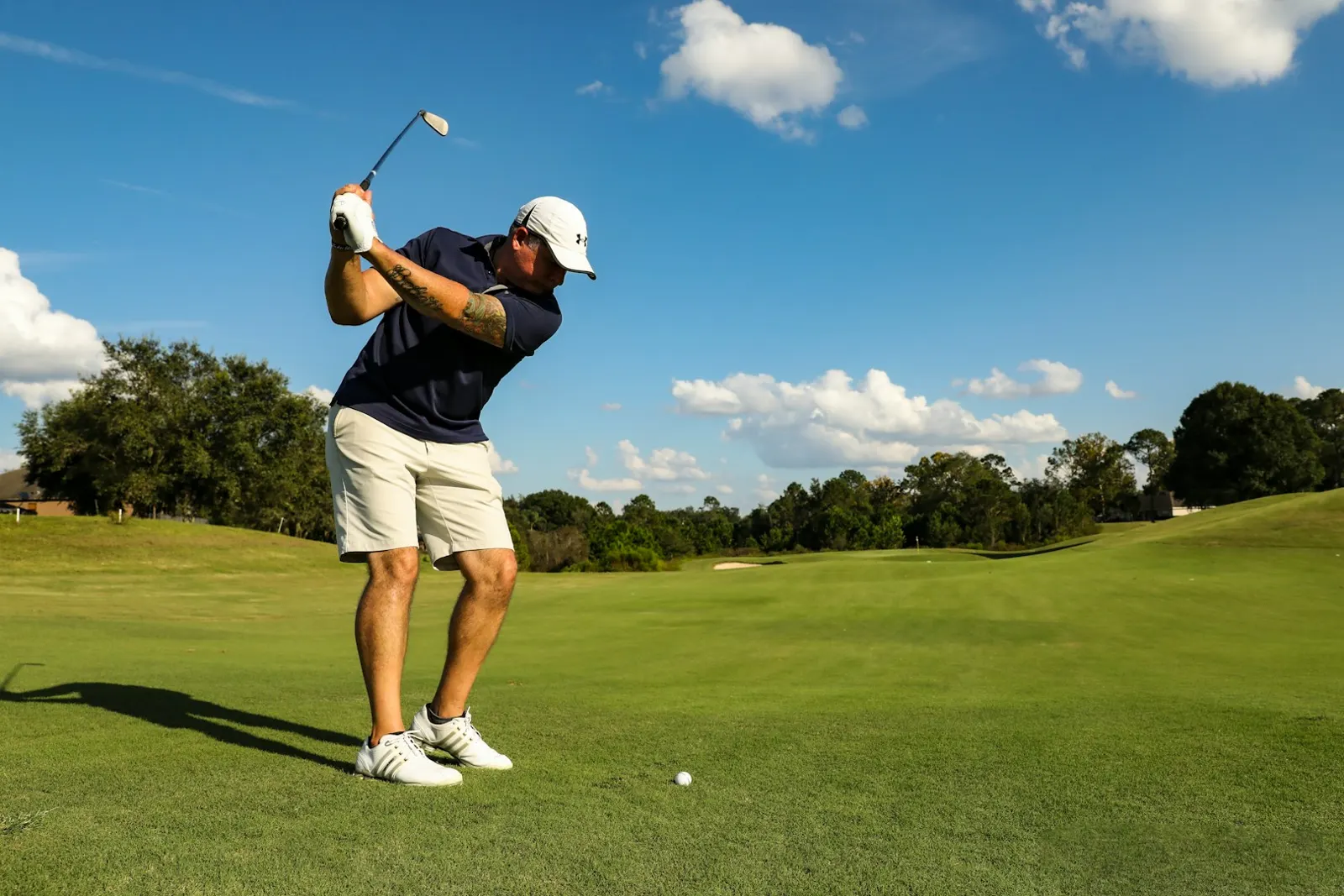 Golfeur au départ d'un trou, au lever du jour